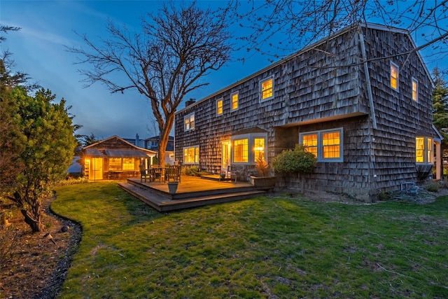back of house featuring a lawn and a deck
