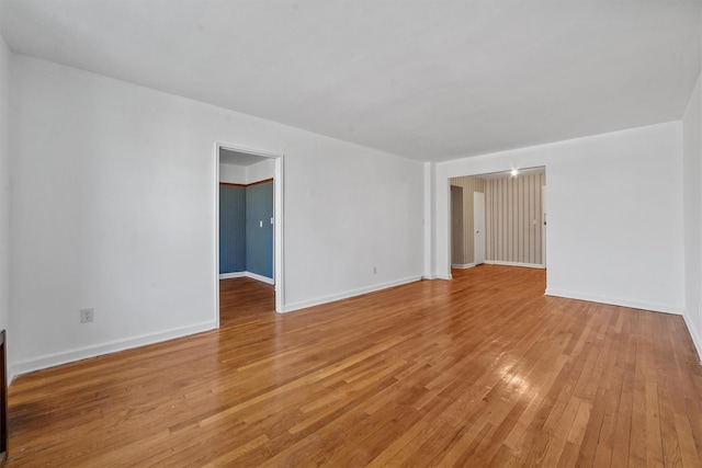 empty room featuring baseboards and light wood-style floors