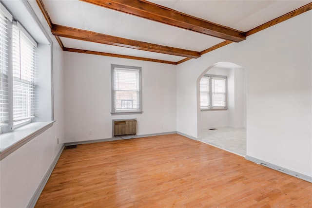 32-12 208th St, Bayside, NY 11361 - unfurnished room featuring radiator, arched walkways, a healthy amount of sunlight, and beamed ceiling