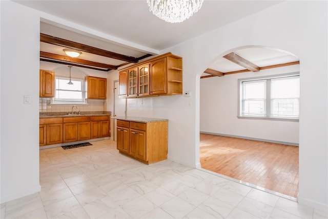 32-12 208th St, Bayside, NY 11361 - kitchen featuring beamed ceiling, brown cabinetry, and arched walkways