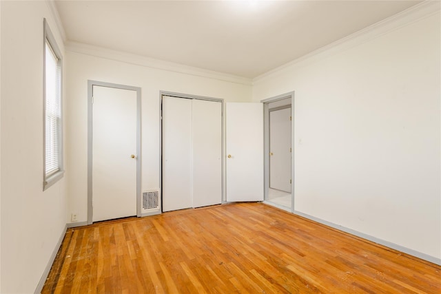 32-12 208th St, Bayside, NY 11361 - unfurnished bedroom with multiple windows, ornamental molding, light wood-style floors, and a closet