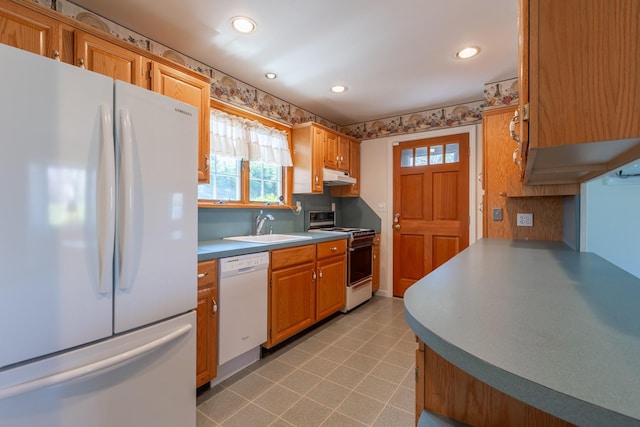kitchen with a wealth of natural light, white appliances, recessed lighting, and under cabinet range hood