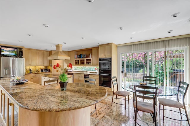 kitchen with light brown cabinets, open shelves, black appliances, a spacious island, and island range hood