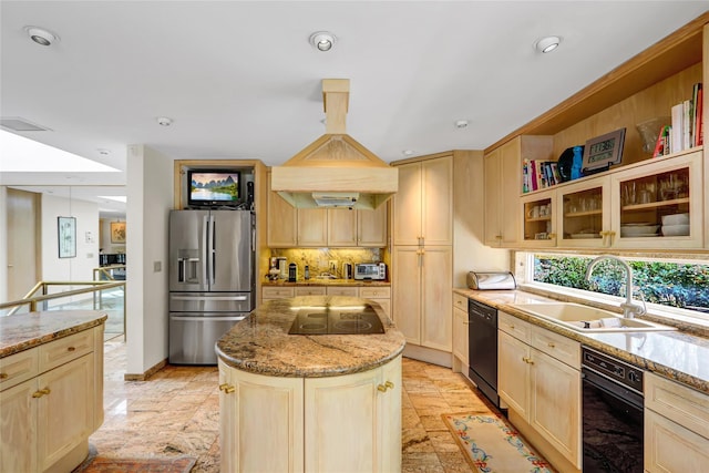 kitchen featuring light stone countertops, a sink, light brown cabinets, a center island, and black appliances