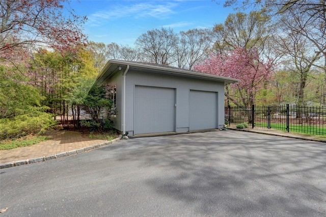 detached garage featuring fence