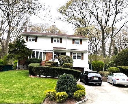view of front of house featuring an attached garage, driveway, and a front yard