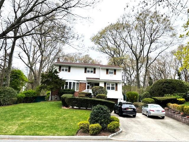 view of front of property with a chimney, a front yard, and concrete driveway