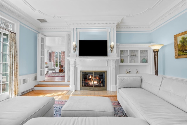 4610 Boston Post Rd, Pelham, NY 10803 - living room featuring radiator heating unit, wood finished floors, ornamental molding, and a fireplace with flush hearth