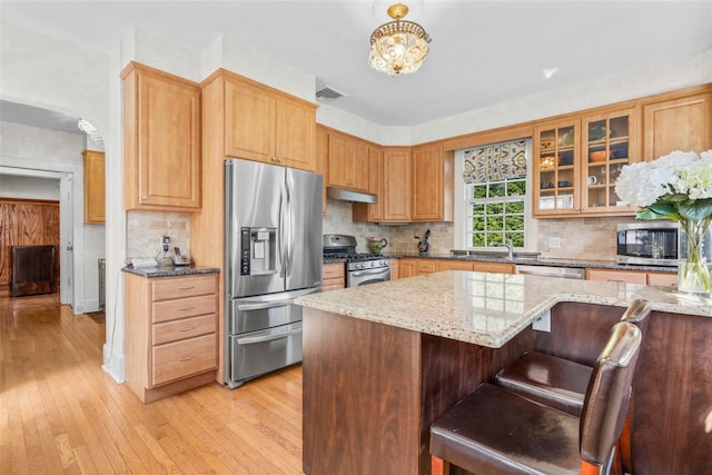 4610 Boston Post Rd, Pelham, NY 10803 - kitchen with stainless steel appliances, under cabinet range hood, light stone countertops, and light wood-style floors