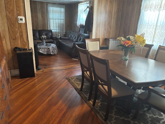 dining space featuring hardwood / wood-style floors and wooden walls
