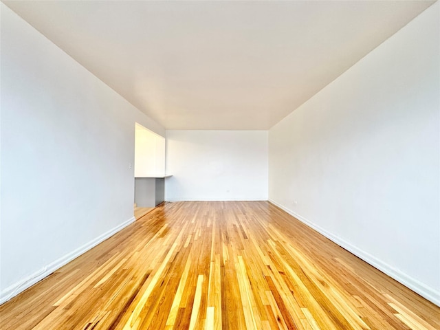 spare room featuring light wood finished floors and baseboards
