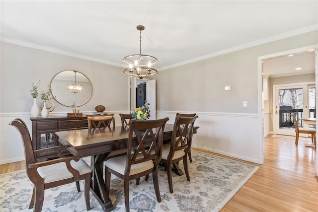 dining room featuring crown molding, a chandelier, and light wood-type flooring