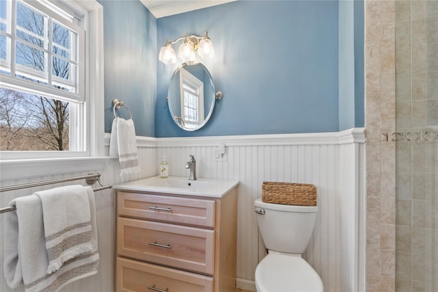 bathroom featuring wainscoting, toilet, and vanity