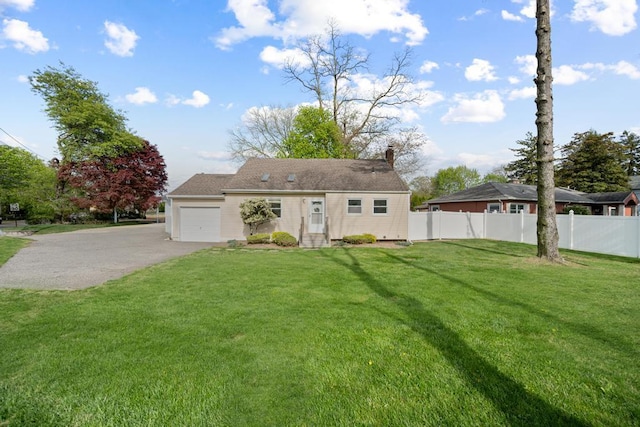 view of front of house featuring a chimney, fence, aphalt driveway, a front yard, and an attached garage