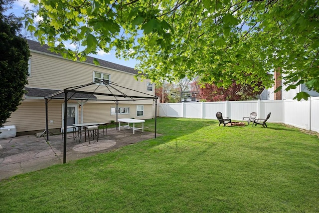 view of yard featuring a patio, a gazebo, a fenced backyard, and an outdoor fire pit