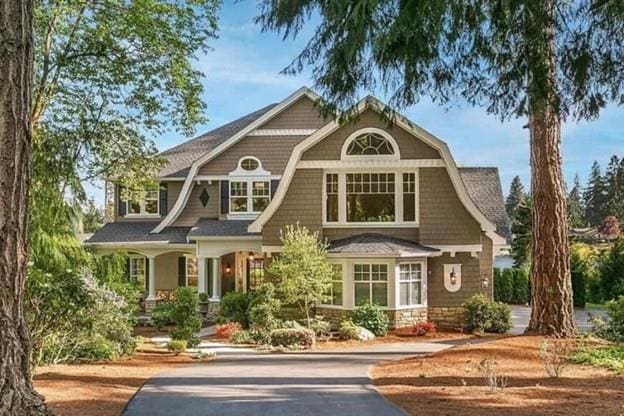 view of front facade featuring a gambrel roof and aphalt driveway