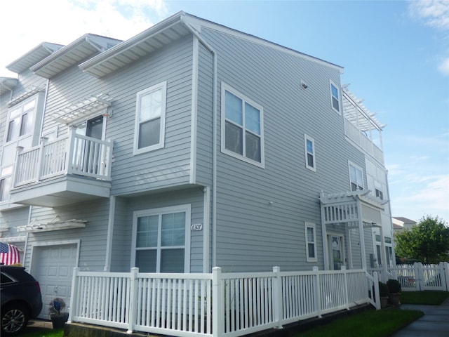 view of side of home with a balcony and a garage