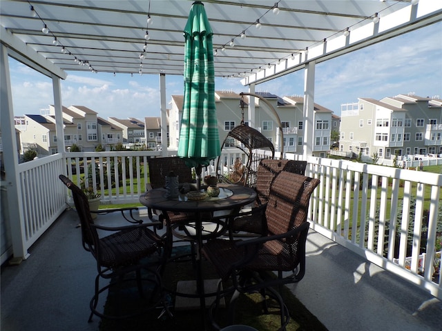 balcony featuring a pergola, outdoor dining area, and a residential view