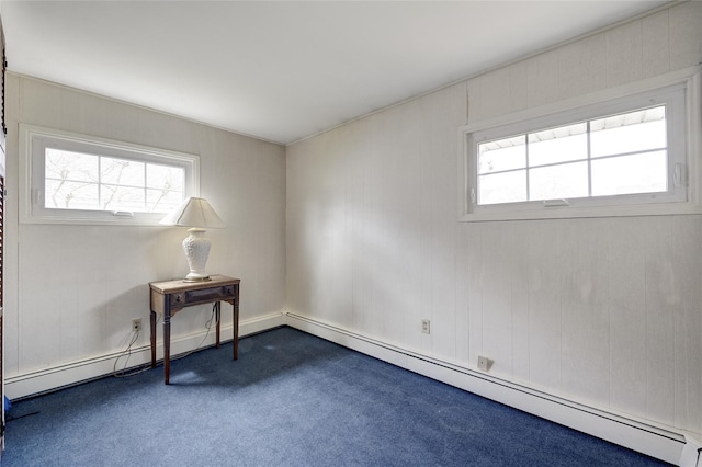 unfurnished room with a baseboard heating unit, a wealth of natural light, and dark colored carpet