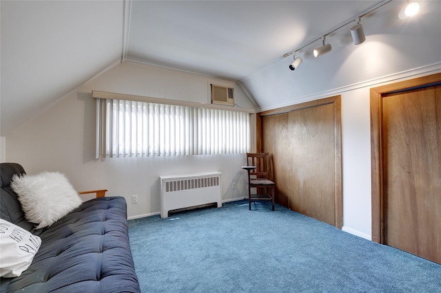 interior space with radiator, lofted ceiling, rail lighting, and baseboards