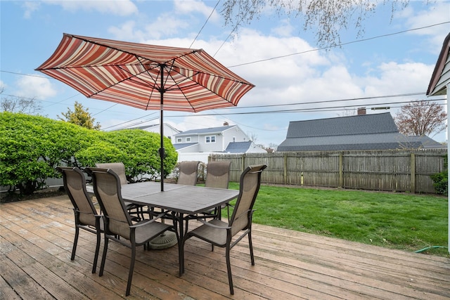 wooden deck featuring a fenced backyard, a yard, and outdoor dining area