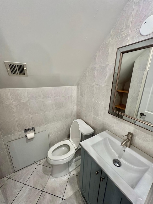 1258 Mace Ave, Bronx, NY 10469 - half bathroom featuring toilet, vanity, tile walls, lofted ceiling, and visible vents