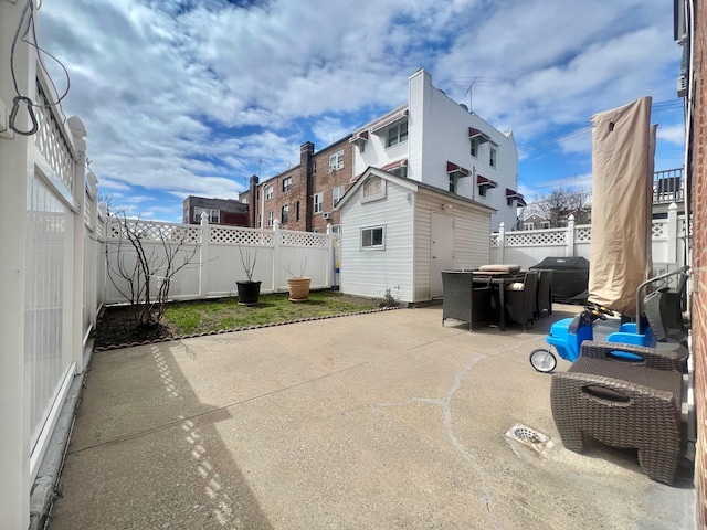 1258 Mace Ave, Bronx, NY 10469 - view of patio with a fenced backyard, grilling area, outdoor dining area, an outbuilding, and a storage unit