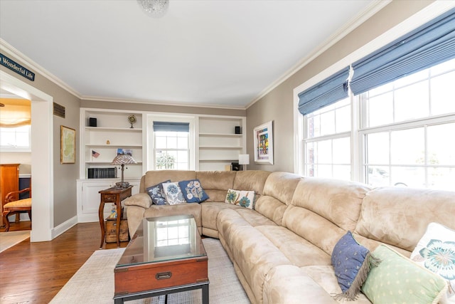 80 Park Ave, New Hyde Park, NY 11040 - living area featuring built in shelves, ornamental molding, and dark wood-style flooring