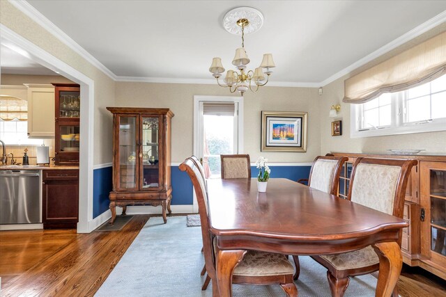 80 Park Ave, New Hyde Park, NY 11040 - dining area featuring dark wood-type flooring, baseboards, ornamental molding, and an inviting chandelier