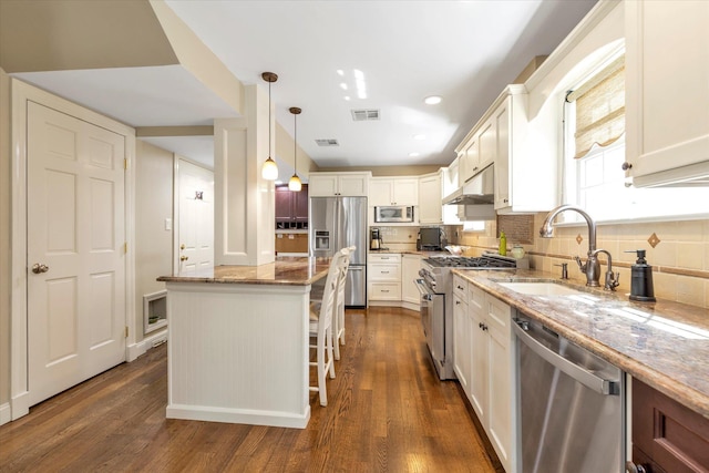 80 Park Ave, New Hyde Park, NY 11040 - kitchen with stainless steel appliances, visible vents, light stone counters, and dark wood-style flooring