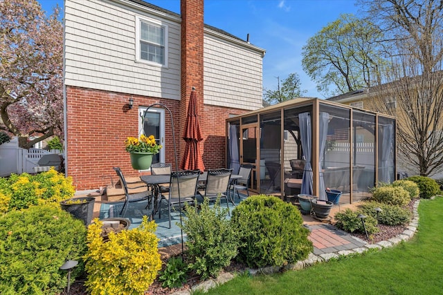 80 Park Ave, New Hyde Park, NY 11040 - back of property with brick siding, a patio area, a sunroom, and a chimney