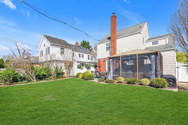 80 Park Ave, New Hyde Park, NY 11040 - rear view of property with a sunroom, a chimney, fence, and a lawn