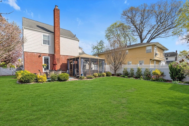 80 Park Ave, New Hyde Park, NY 11040 - back of house featuring a yard, a sunroom, a fenced backyard, and a chimney