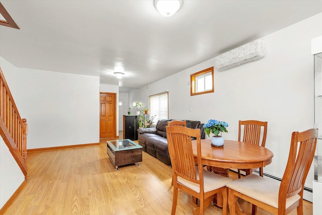 dining room with baseboards, light wood-style flooring, and stairway