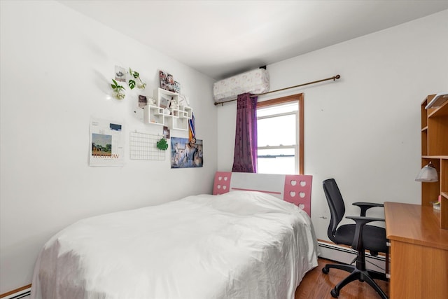 bedroom with a baseboard heating unit, wood finished floors, and a baseboard radiator