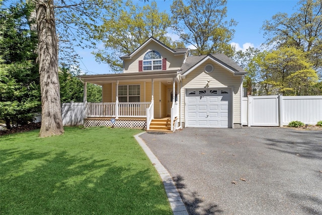 view of front of home with covered porch, fence, driveway, and a garage