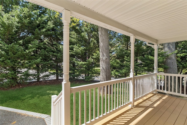 wooden deck with a lawn and covered porch