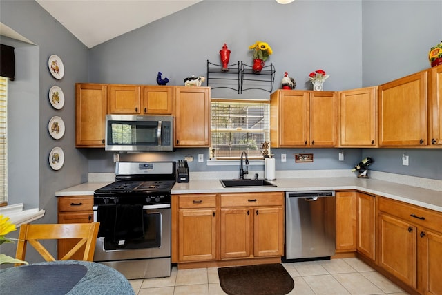kitchen with light countertops, stainless steel appliances, light tile patterned floors, and a sink