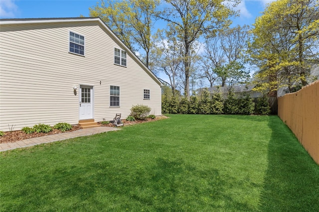 exterior space featuring entry steps, fence, and a lawn
