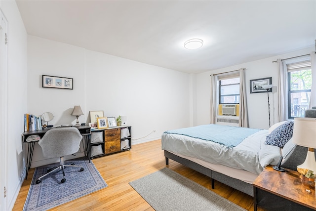 bedroom with cooling unit and light wood-type flooring