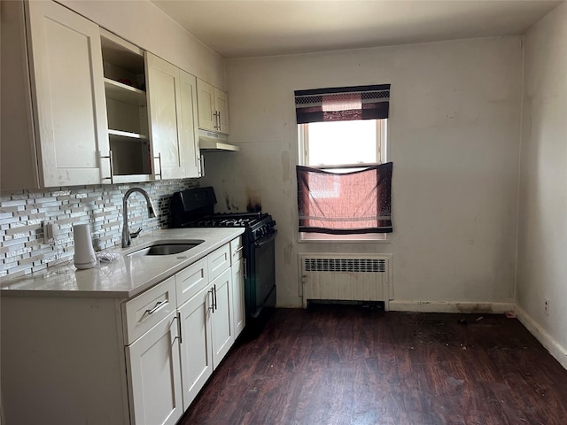 kitchen featuring radiator heating unit, black gas stove, a sink, light countertops, and under cabinet range hood