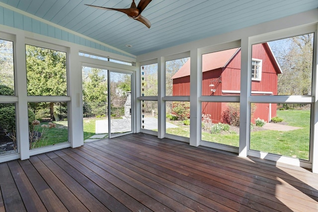 unfurnished sunroom featuring ceiling fan