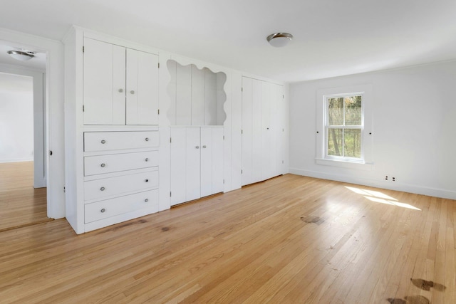 unfurnished bedroom with baseboards and light wood-style floors