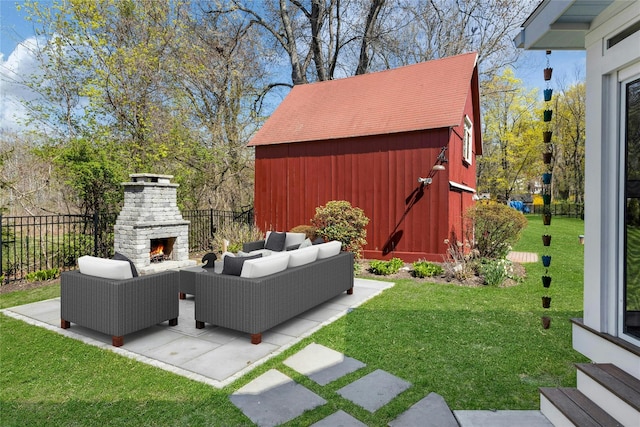 view of yard with fence, an outdoor living space with a fireplace, entry steps, and a patio area