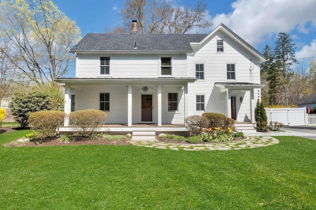view of front of house featuring a chimney, a porch, and a front lawn
