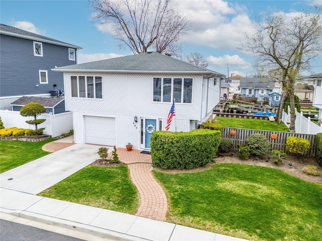 view of front facade with a garage, fence, and a front yard
