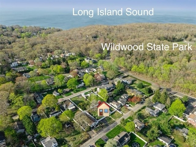 birds eye view of property with a water view, a view of trees, and a residential view