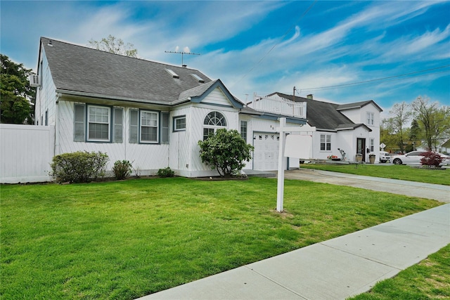 view of front of home with fence, a front yard, driveway, and an attached garage