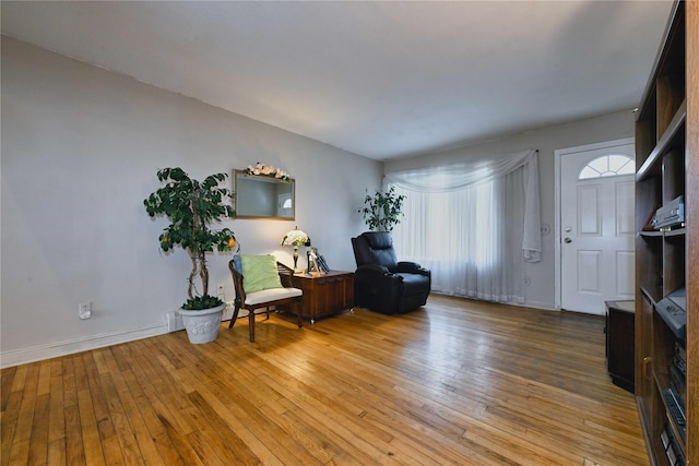 sitting room with baseboards and wood-type flooring