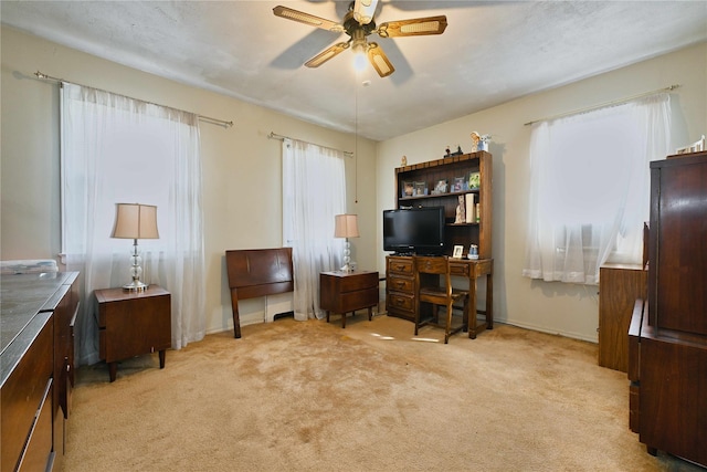 office featuring ceiling fan, light colored carpet, and baseboards
